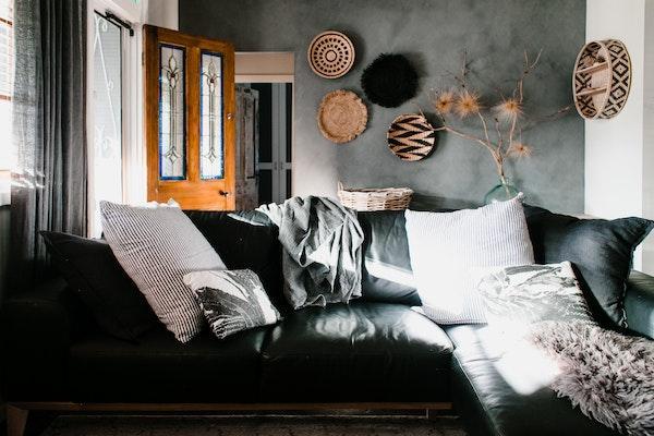 A black sofa with grey pillows