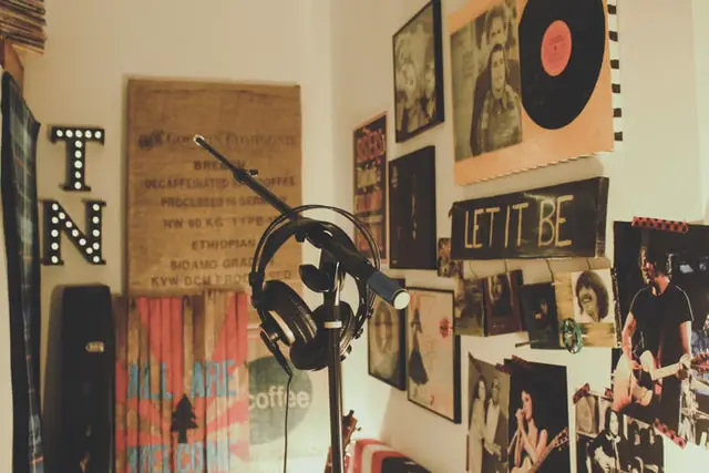  A headset and microphone in the corner of a room with posters on the wall