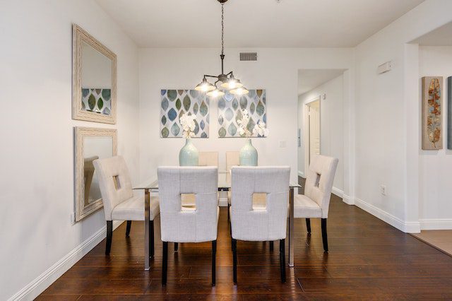 A dining room with a large table, some chairs, and well-decorated walls.