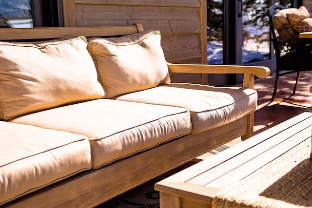 A wooden outdoor sofa and a table.